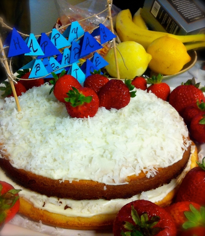 Coconut cake with lemon zest, mascarpone frosting, topped with stawberries.